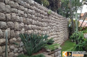 6. Muro pequeno de pedra do mato (moledo) com acabamento rustico, sendo  pedras boleadas nas laterais. Em cima foi feito um espaç…